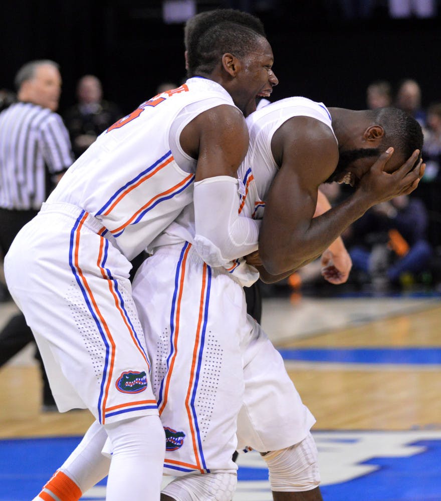 Will Yeguete jumps on teammate Patric Young's back in celebration following Florida's 62-52 win against Dayton on Saturday in FedEx Forum in Memphis, Tenn.