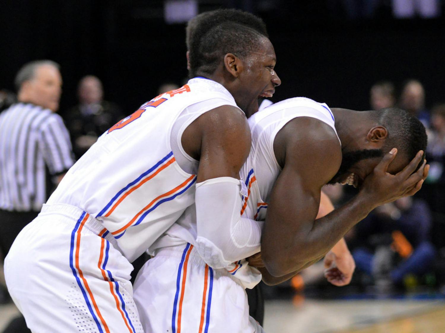 Will Yeguete jumps on teammate Patric Young's back in celebration following Florida's 62-52 win against Dayton on Saturday in FedEx Forum in Memphis, Tenn.