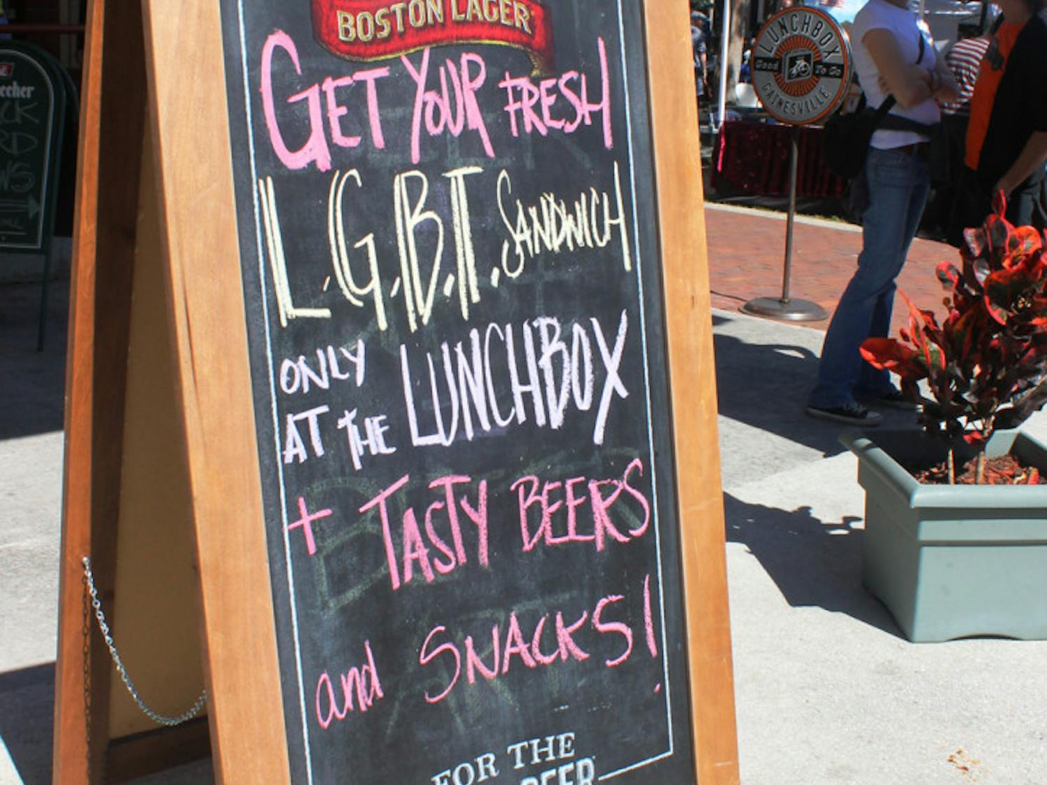 A sign advertising a Pride-friendly specialty sandwich sits in front of The Lunchbox, a cafe in downtown Gainesville.
