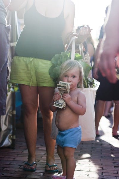 Koa Conley, 18 months, waits in line to buy a pint of blueberries from Wellborn Farm Blueberries at the 16th anniversary of the Union Street Farmers Market on Wednesday.