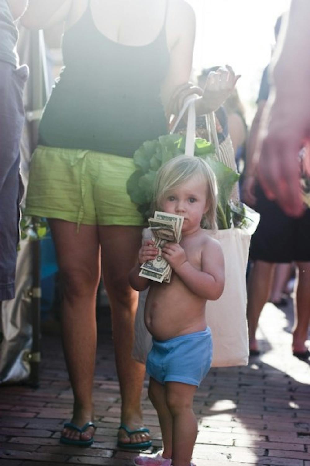 <p>Koa Conley, 18 months, waits in line to buy a pint of blueberries from Wellborn Farm Blueberries at the 16th anniversary of the Union Street Farmers Market on Wednesday.</p>