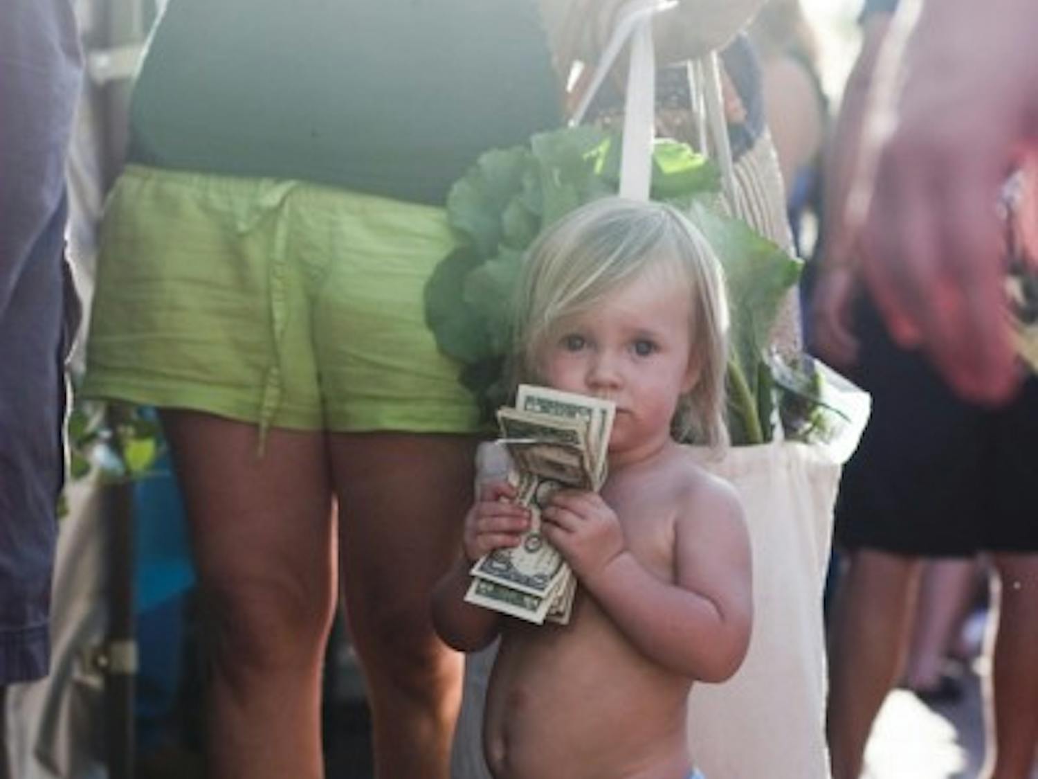 Koa Conley, 18 months, waits in line to buy a pint of blueberries from Wellborn Farm Blueberries at the 16th anniversary of the Union Street Farmers Market on Wednesday.