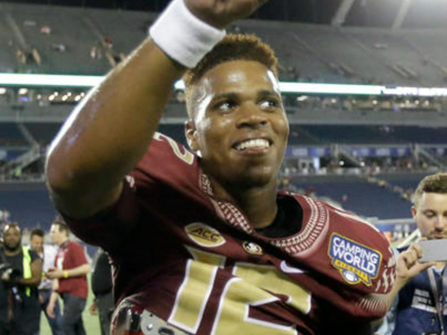 Florida State quarterback Deondre Francois points to cheering fans after defeating Mississippi 45-34 in an NCAA college football game, Tuesday, Sept. 6, 2016, in Orlando, Fla. (AP Photo/John Raoux)