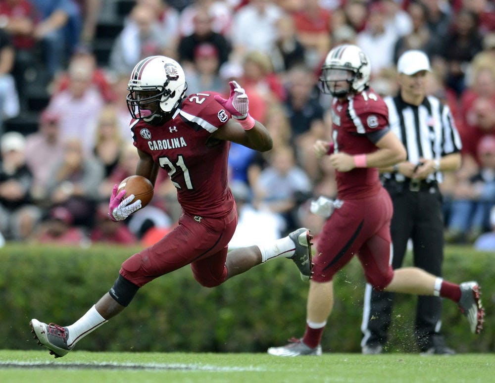 In this Oct. 27, 2012, file photo, South Carolina running back Marcus Lattimore (21) rushes up field after taking the hand off from quarterback Connor Shaw, back, during an NCAA college football game against Tennessee in Columbia, S.C.