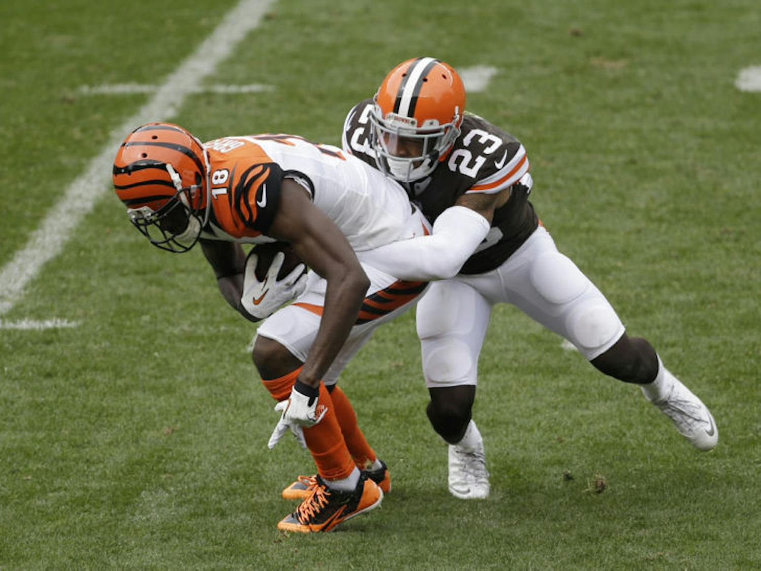 Cleveland Browns cornerback Joe Haden (right) tackles Cincinnati Bengals A.J. Green during an NFL football game in Cleveland