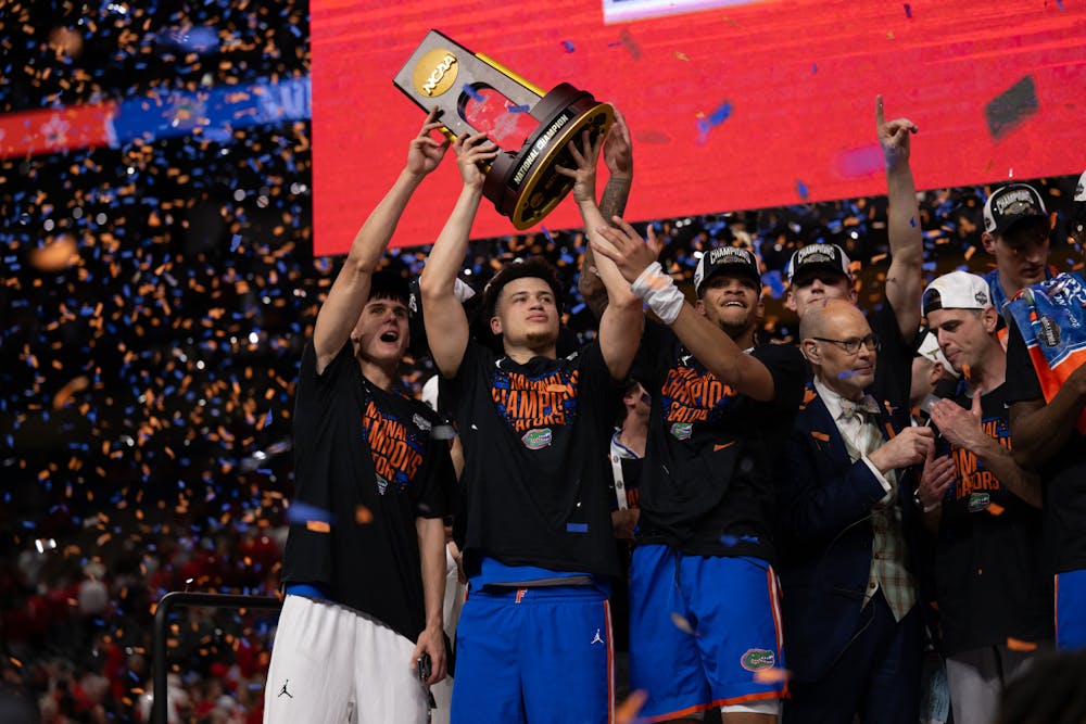 Florida Gators guard Walter Clayton Jr. (1) surrounded by teammates, raises the national championship trophy after winning the National Championship against the Houston Cougars in the NCAA Tournament on Monday, April 7, 2025, in San Antonio, Texas.