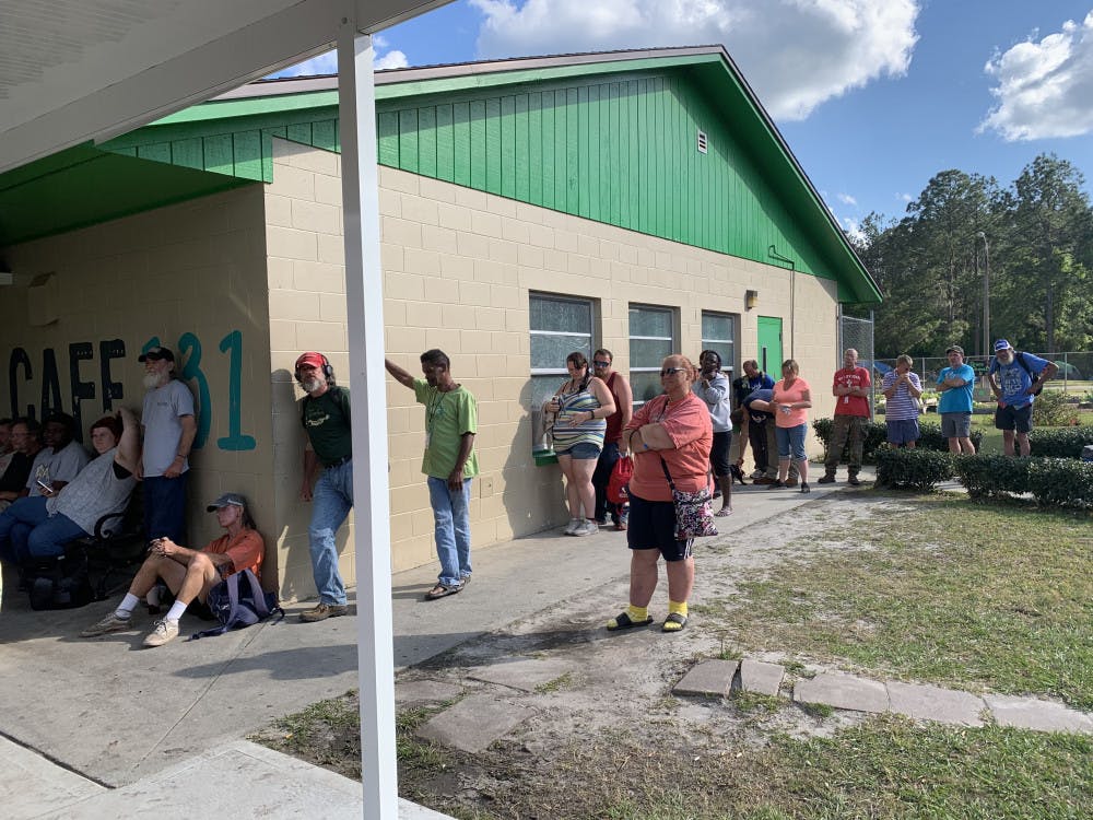 Attendees wait in line for meals outside Cafe 131 at Grace Marketplace on Monday evening. The non-profit assistance shelter celebrated serving its half millionth meal. 