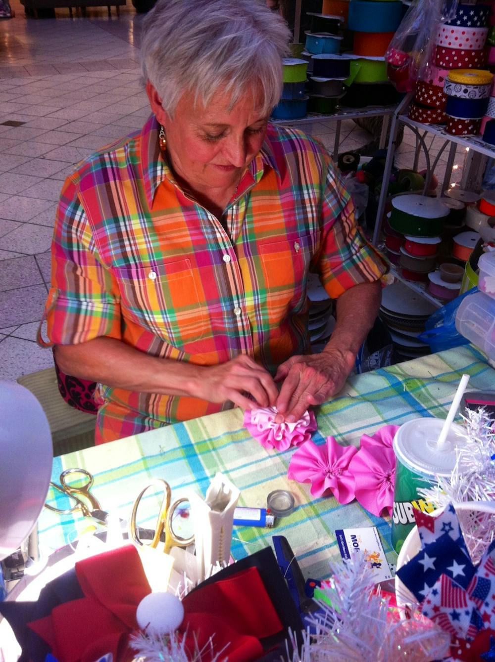 <p>Beverly Watson makes flowers for one of her many headbands in her collection on display at The Oaks Mall Art, Craft &amp; Lifestyle show during the weekend.</p>