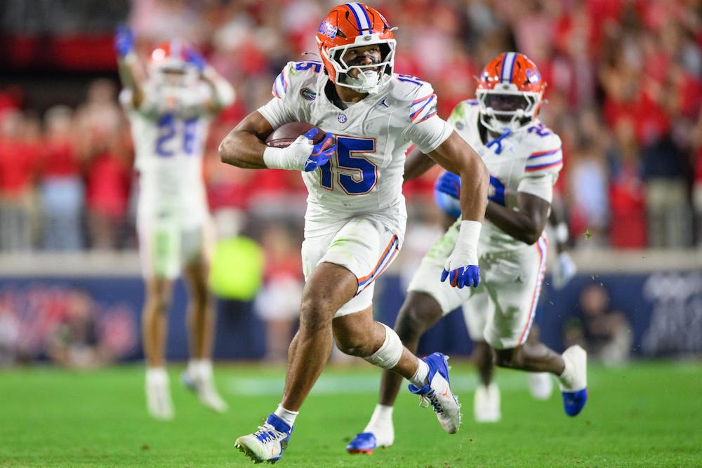 Florida edge rusher Jayden Woods (15) runs with the ball after an interception during an NCAA college football game, Saturday, Nov. 15, 2025, in Oxford, Miss.
