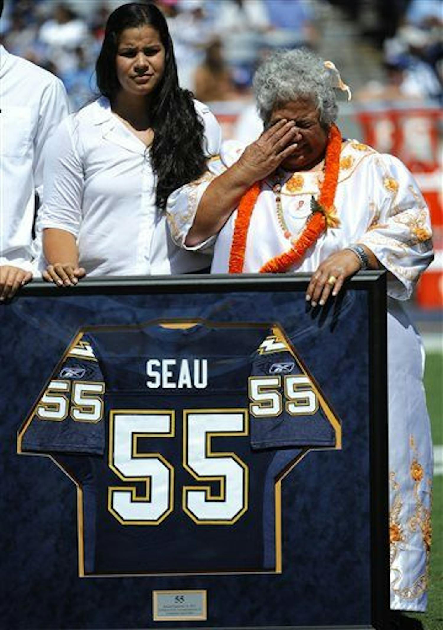 Luisa Seau, right, the mother of former San Diego Chargers linebacker Junior Seau, wipes her eyes during a ceremony on&nbsp;Sept. 16, 2012,&nbsp;to retire Seau's No. 55 uniform before the Chargers play the Tennessee Titans in an NFL football game in San Diego.