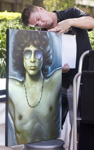 Eddie Myers, a 39-year-old artist from Lake Mary, measures his Jim Morrison piece at the Gainesville Fine Arts Association's 28th annual GFAA Art Festival at Thornebrook over the weekend.