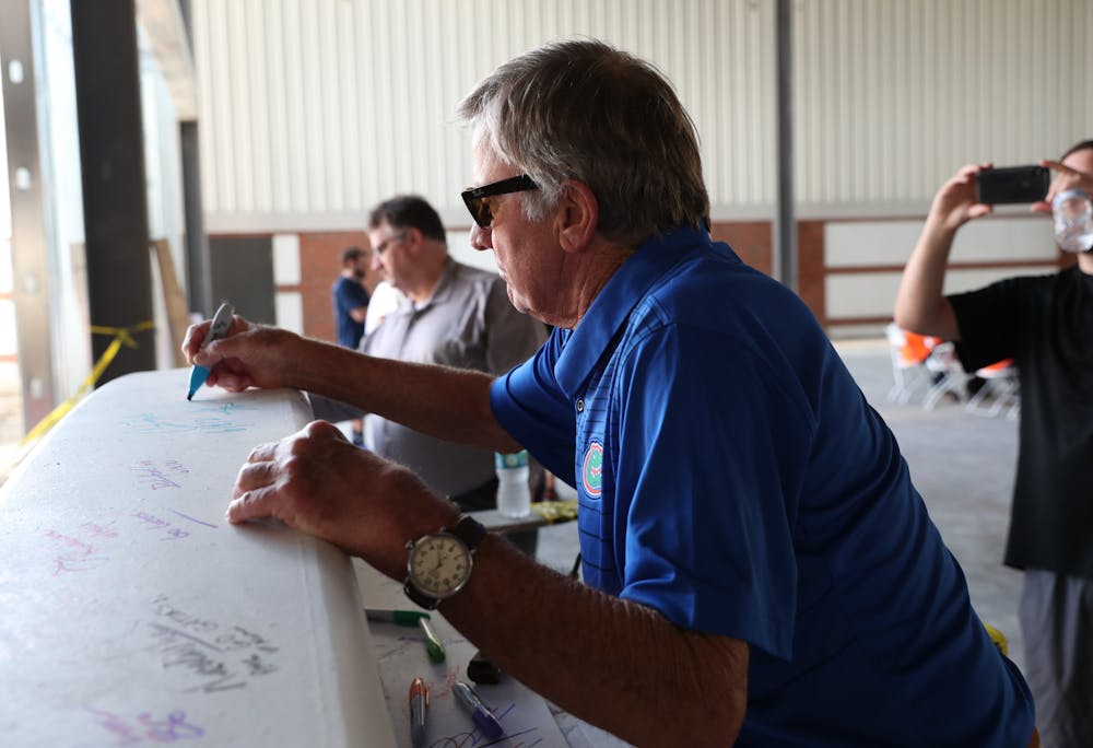 Florida Gators Athletic Department ambassador Steve Spurrier autographs the final steel beam at the James W. “Bill” Heavener Football Training Center at the facility’s topping-out ceremony on Tuesday, June 8.