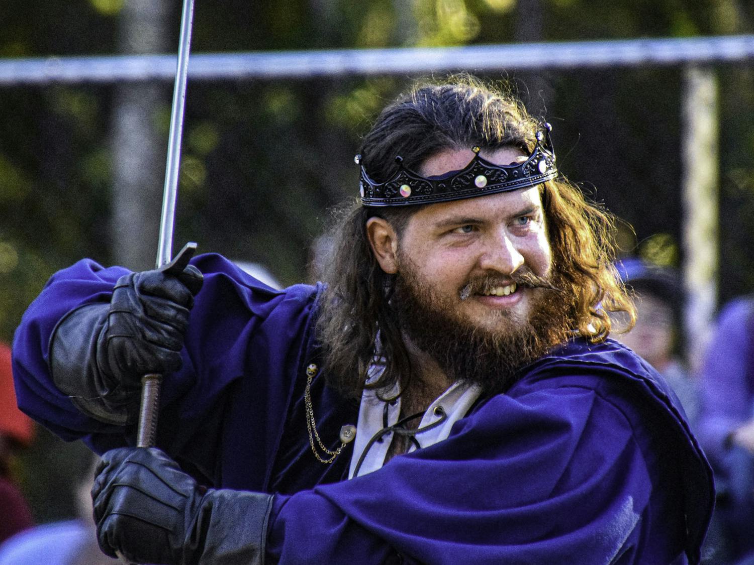 Cody Ward, a 29-year-old actor with volunteer acting troupe Thieves Guilde, brandishes a sword to play-fight an opponent during a life-sized game of chess at the Hoggetowne Medieval Faire.
