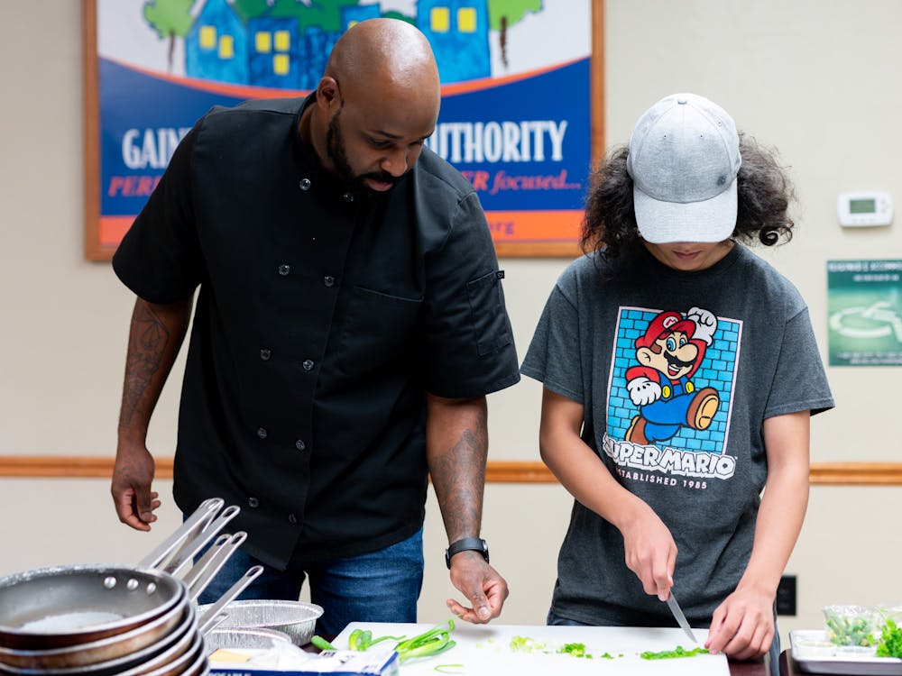 A participant is guided during an Underground Kitchen cooking class on Saturday, May 25, 2024.