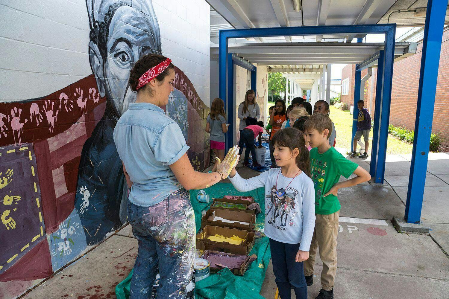 Artist Jenna Horner helps students apply paint to their hands. Photos by Iryna Kanishcheva.
&nbsp;