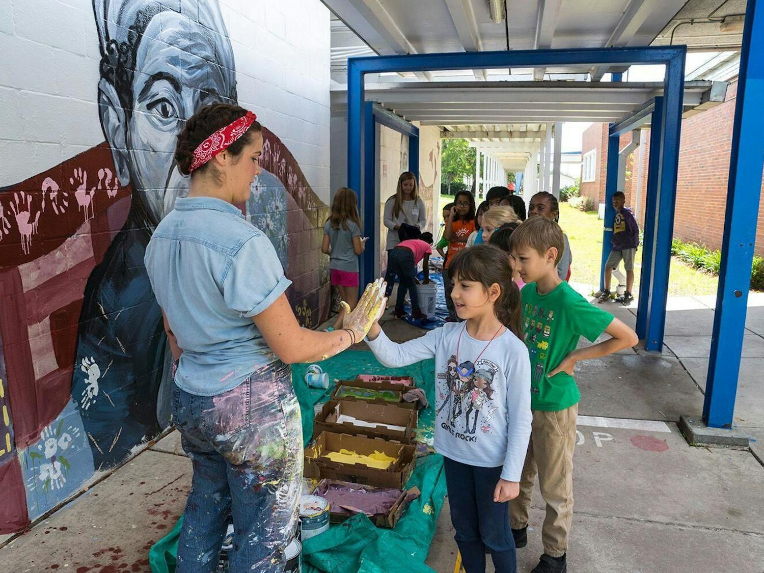 Artist Jenna Horner helps students apply paint to their hands. Photos by Iryna Kanishcheva.
&nbsp;