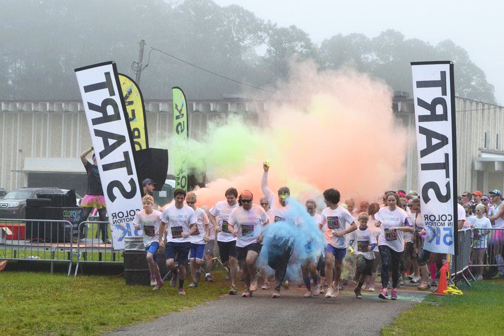 <p>The first wave of runners dash off the starting line during the Color in Motion 5K run at the Alachua County Fairgrounds on Jan. 16, 2016.</p>