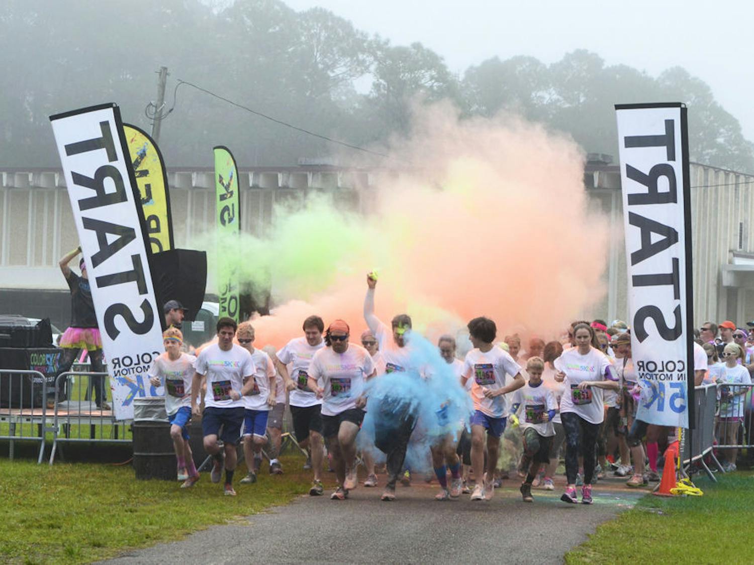 The first wave of runners dash off the starting line during the Color in Motion 5K run at the Alachua County Fairgrounds on Jan. 16, 2016.