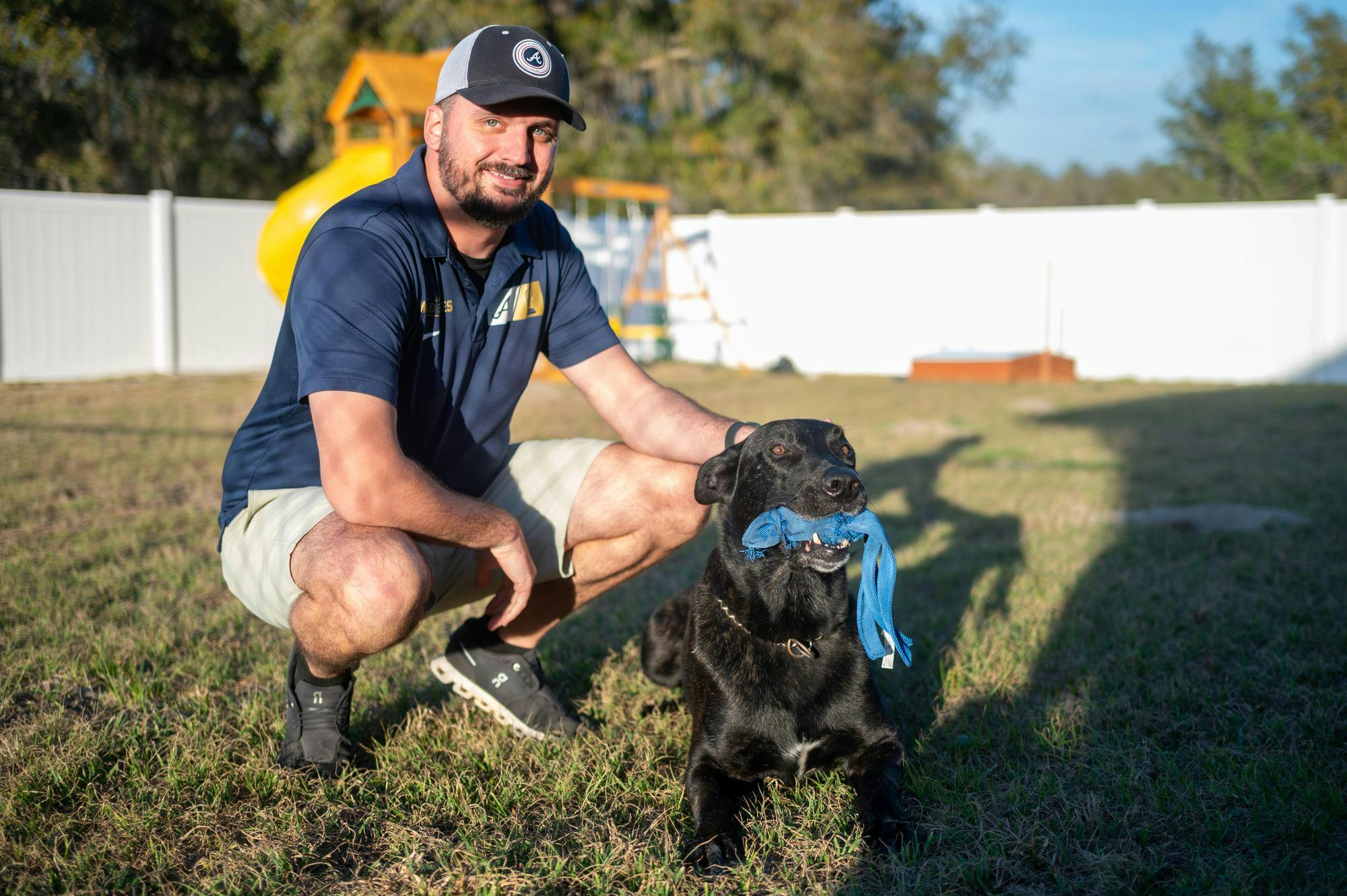 Jeffrey Stadnicki poses with Ozzie, a newly retired police dog, in their backyard, Wednesday, Feb. 18, 2026, in Melrose, Fla.