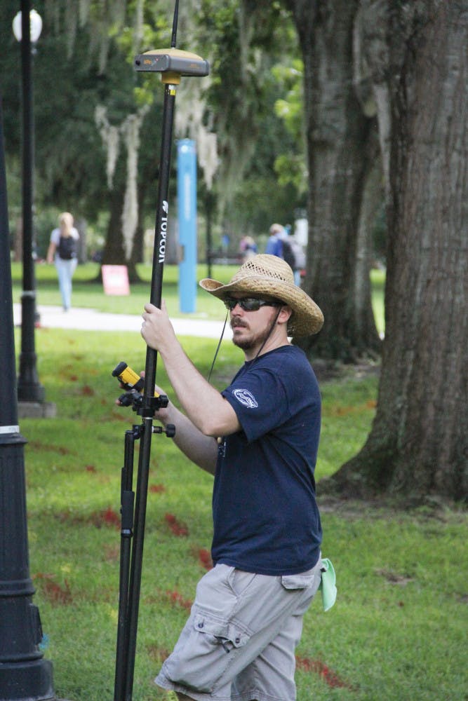 Research assistant H. Andrew Lassiter works on a Real-Time Kinematic survey, a technique that enhances GPS, near Weimer Hall on Sept. 8, 2015. Lassiter said he spent Labor Day grading papers after the rain cut his outdoor research short.
