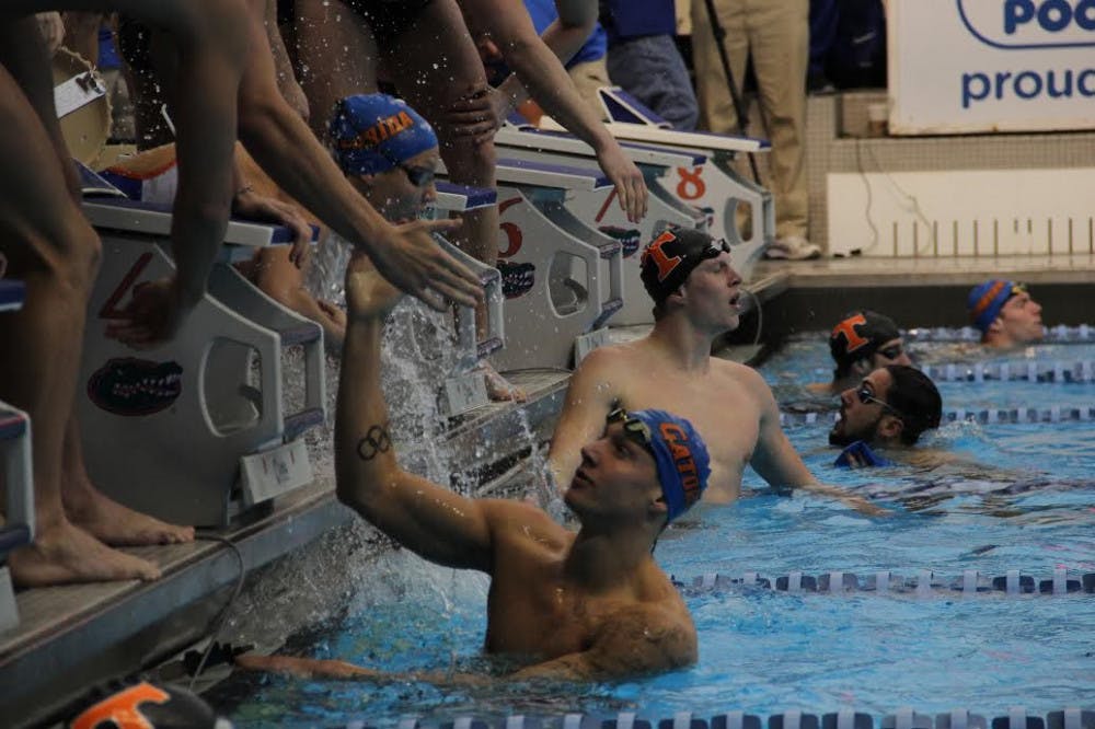 <p>UF swimmer Caeleb Dressel slaps hands with a teammate during Florida's <span>183-117 win against Tennessee</span>&nbsp;on Jan. 28, 2017, in the O'Connell Center.&nbsp;</p>