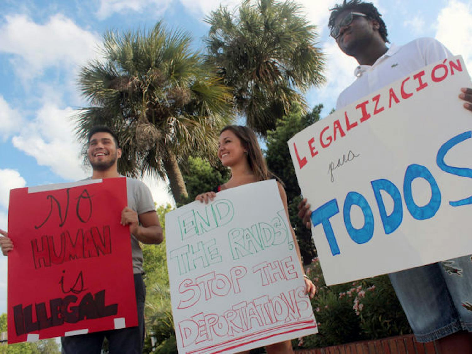 Students for a Democratic Society members hold signs Friday by University Avenue and 13th Street. They demanded Florida driver’s licenses for undocumented people and legalization for all immigrants.