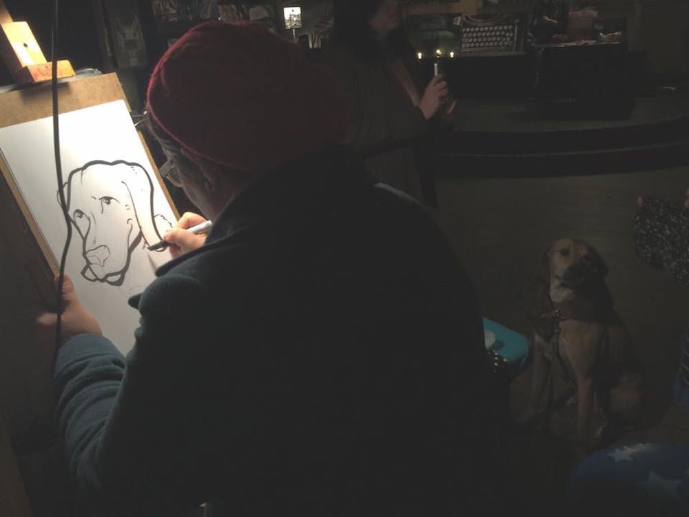 <p dir="ltr" align="justify">Local caricature artist Corinne Halley draws a caricature of a patron’s dog during February’s Art Attack at High Dive, 210 SW Second Ave. High Dive’s Art Attack will be part of Artwalk Gainesville for the first time on Friday. While the event is free, donations are welcomed to keep the event free of charge for its patrons and vendors.</p>