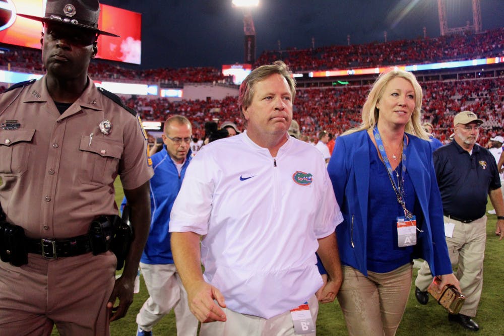 <p>Jim McElwain walks off the field after Florida's 42-7 loss to Georgia on Saturday at EverBank Field in Jacksonville. On Sunday, it was confirmed that McElwain and the UAA mutually agreed to part ways.</p>
