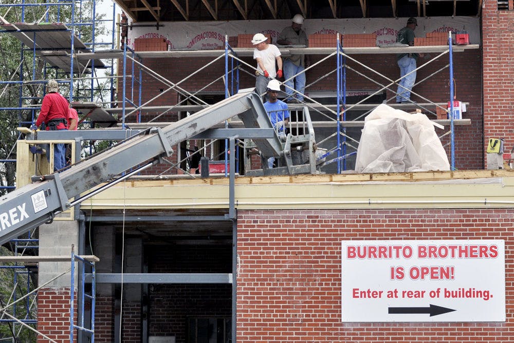 Construction workers fill out the exterior of Burrito Bros' remodeled restaurant on Monday. Northwest 14th Street, between Gator Wesley and Burrito Bros., was closed due to the restaurant's remodelling.