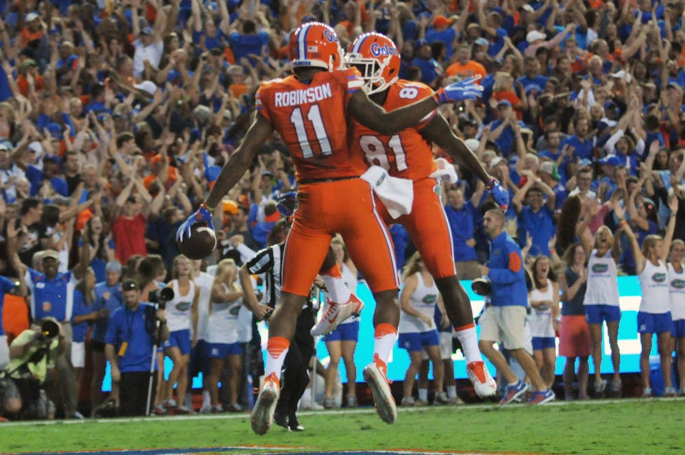 <p>UF wide receivers Demarcus Robinson (11) and Antonio Callaway (81) celebrate after Robinson's first-quarter touchdown during Florida's 38-10 win against Ole Miss on Oct. 3, 2015, at Ben Hill Griffin Stadium.</p>