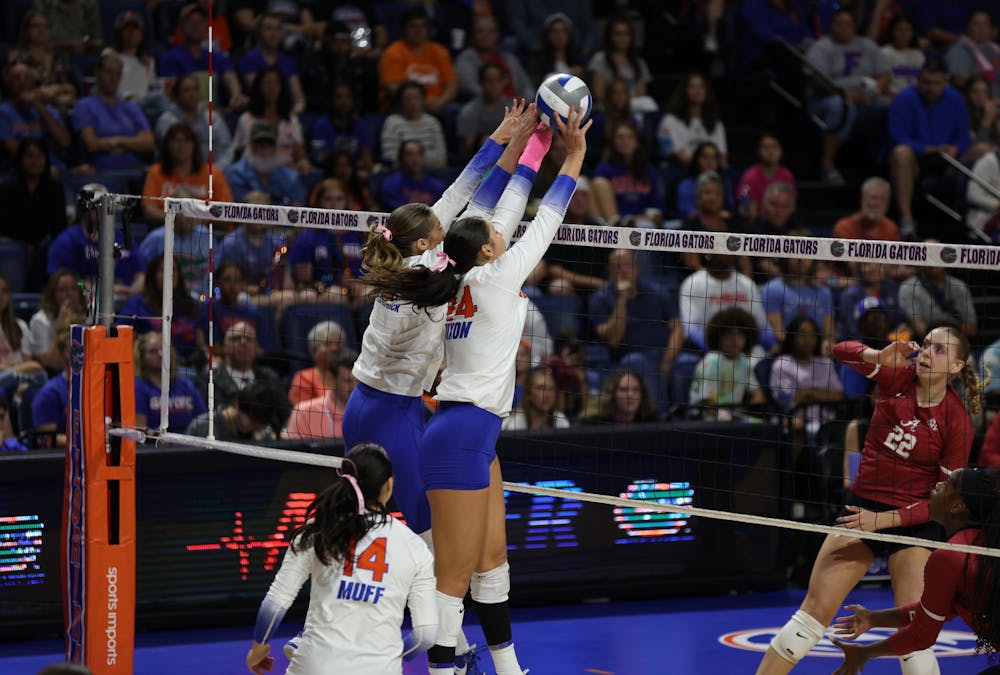 Outside hitters graduate student Anna Dixon and senior AC Fitzpatrick block the ball during the Gators' match against the Alabama Crimson Tide on Sunday, October 8, 2023 at the Stephen C. O'Connell Center.