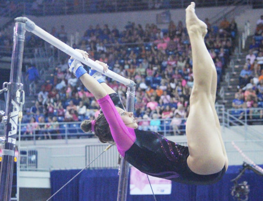 <p>Senior Alaina Johnson performs on the uneven bars during UF’s 198.125-197.625 win against LSU on Feb. 21.</p>