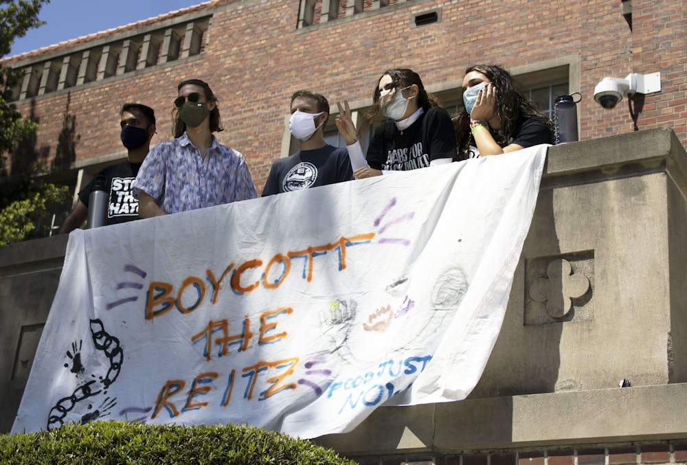 Members of the Food Justice Coalition pose for a photo with a "Boycott the Reitz" banner that was hung outside of the Tigert Hall administration building on Friday, April 23, 2021. 