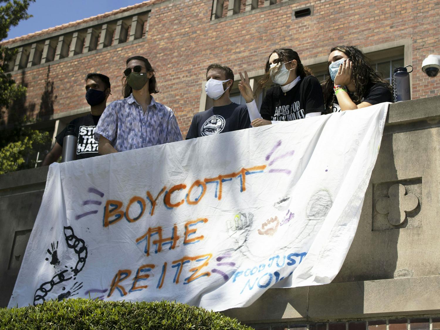 Members of the Food Justice Coalition pose for a photo with a "Boycott the Reitz" banner that was hung outside of the Tigert Hall administration building on Friday, April 23, 2021. 