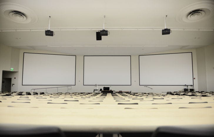 Three new projector screens, each 20 feet wide, hang in Carleton Auditorium as part of UFIT's major renovation project for the summer. Additional work included water damage repairs, improved lighting and stage ability, as well as the installation of a new audio system and high definition projectors.