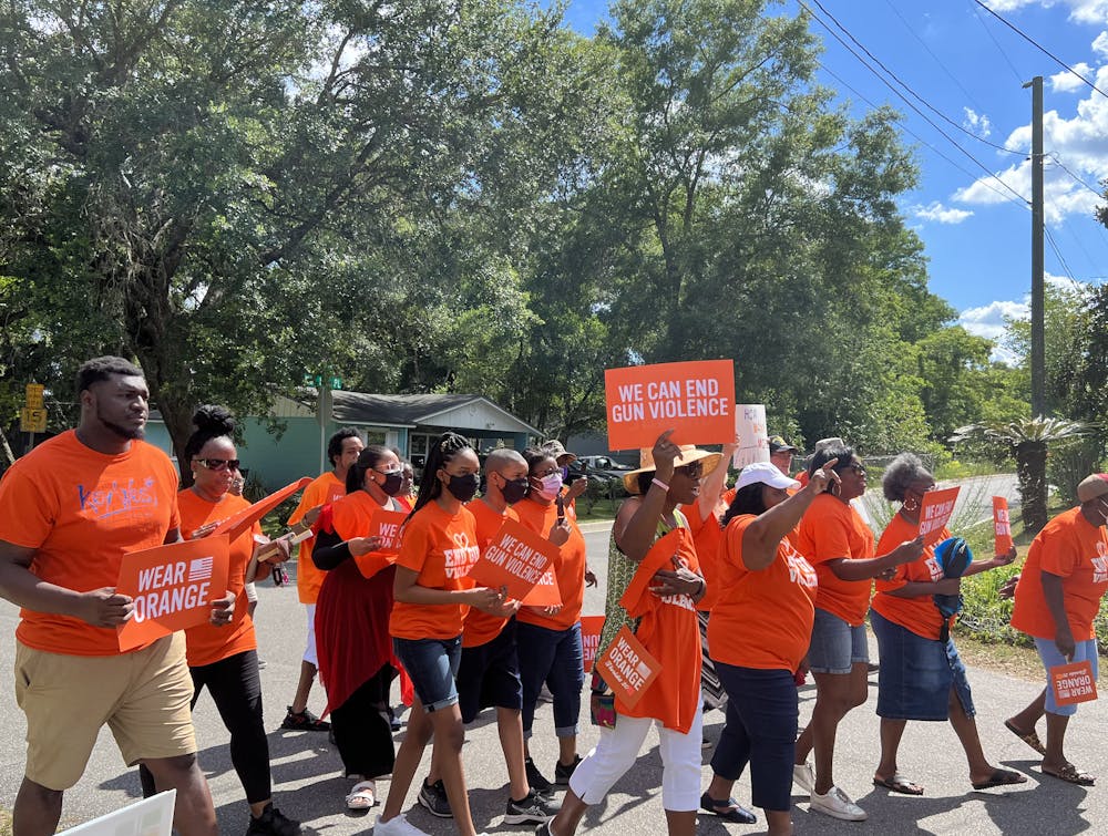 <p>About 50 people march from Westside Church of God in Christ to Maude Lewis Park to protest gun violence and honor victims during the We Wear Orange campaign June 4, 2022.</p>