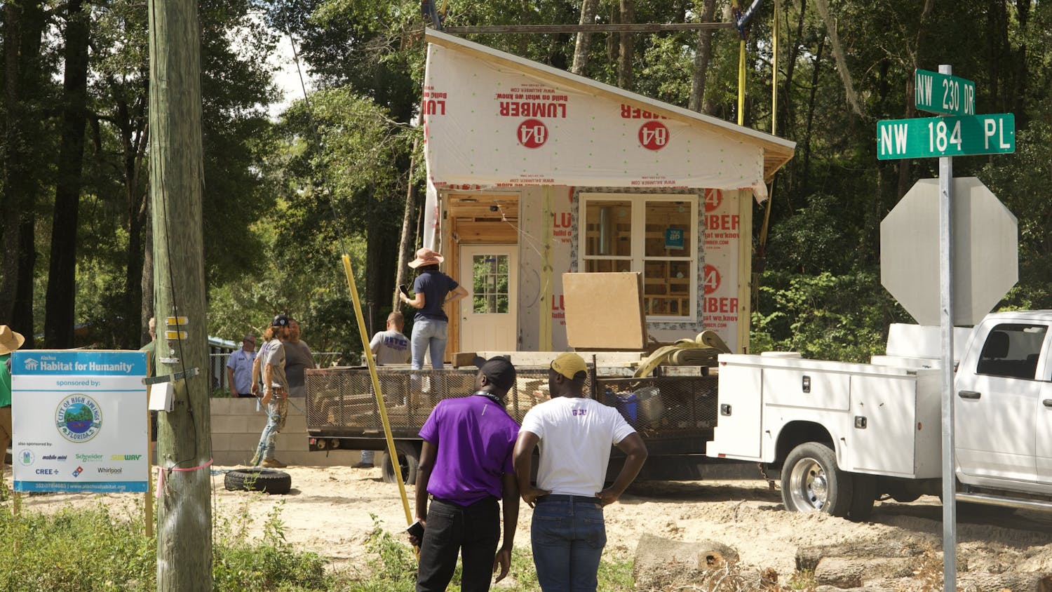 Alachua Habitat for Humanity, Santa Fe professors and construction workers prepare to place the second half of a modular home as two spectators watch at High Springs on Thursday, June 8, 2023.