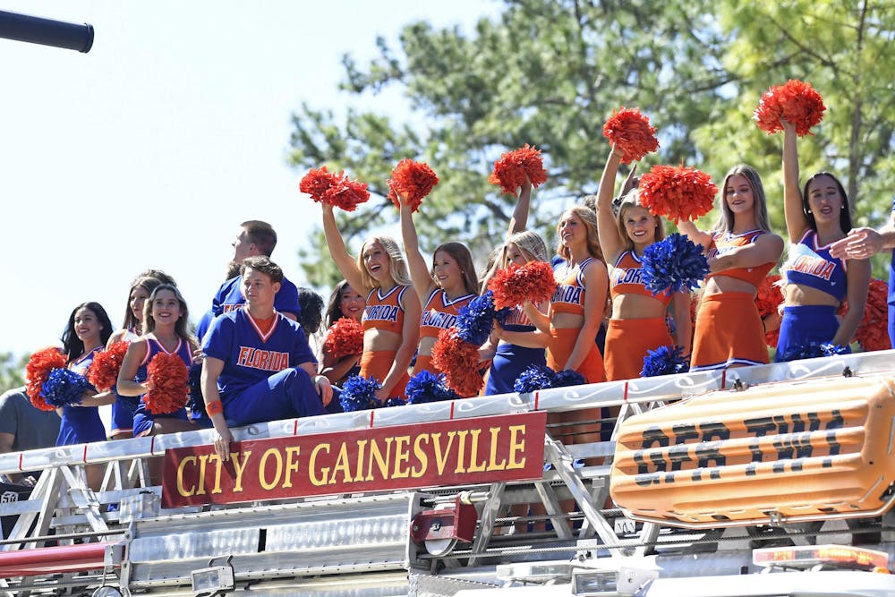 Gator cheerleaders wave to bystanders on a float during the 2024 UF Homecoming parade on Friday, Oct. 18, 2024