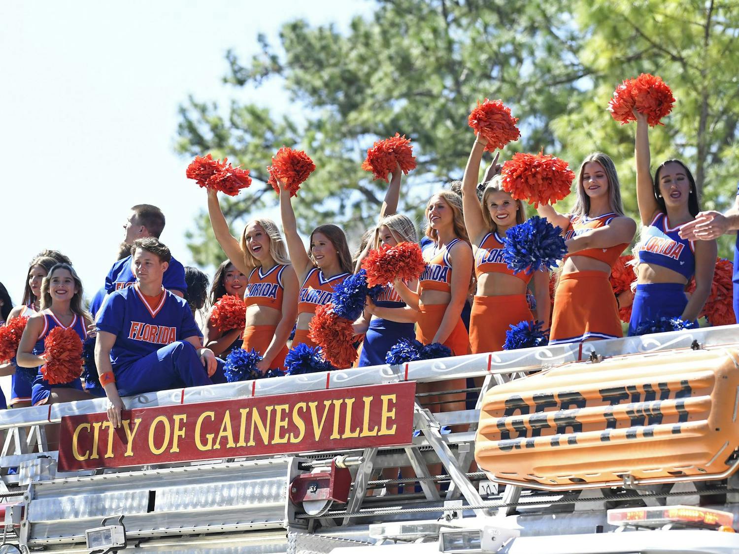 Gator cheerleaders wave to bystanders on a float during the 2024 UF Homecoming parade on Friday, Oct. 18, 2024