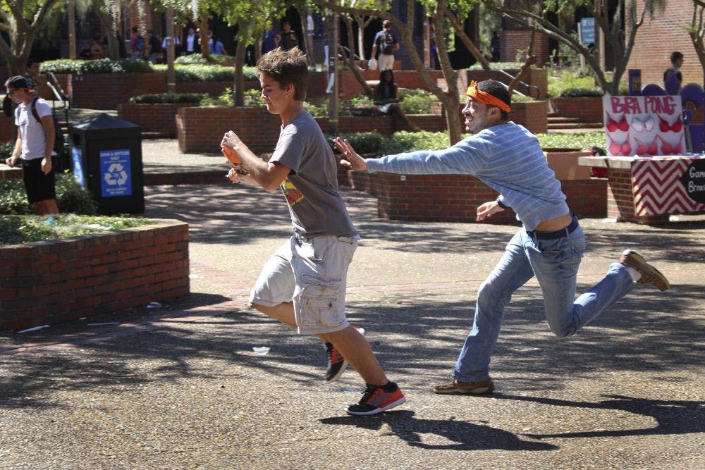 <p>David Ayers chases Maddox Corcoran, a 20-year-old UF economics junior, on Turlington Plaza on Oct. 12, 2015. Gators Humans vs. Zombies began its four-day Summer game on Wednesday.</p>