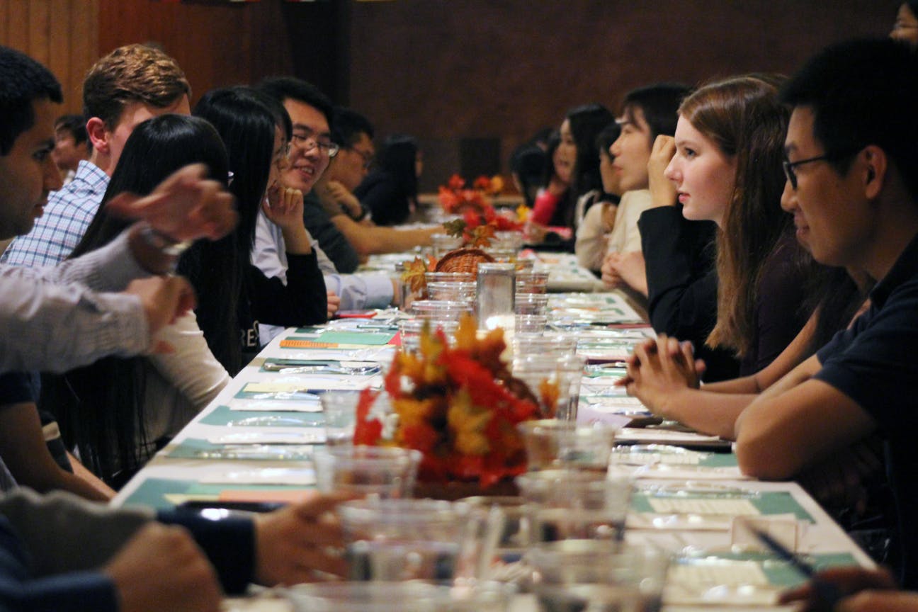Strangers sit together and wait for their food before the banquet begins. Typically, UF President Kent Fuchs would have attended and spoken but instead had to attend the football game.