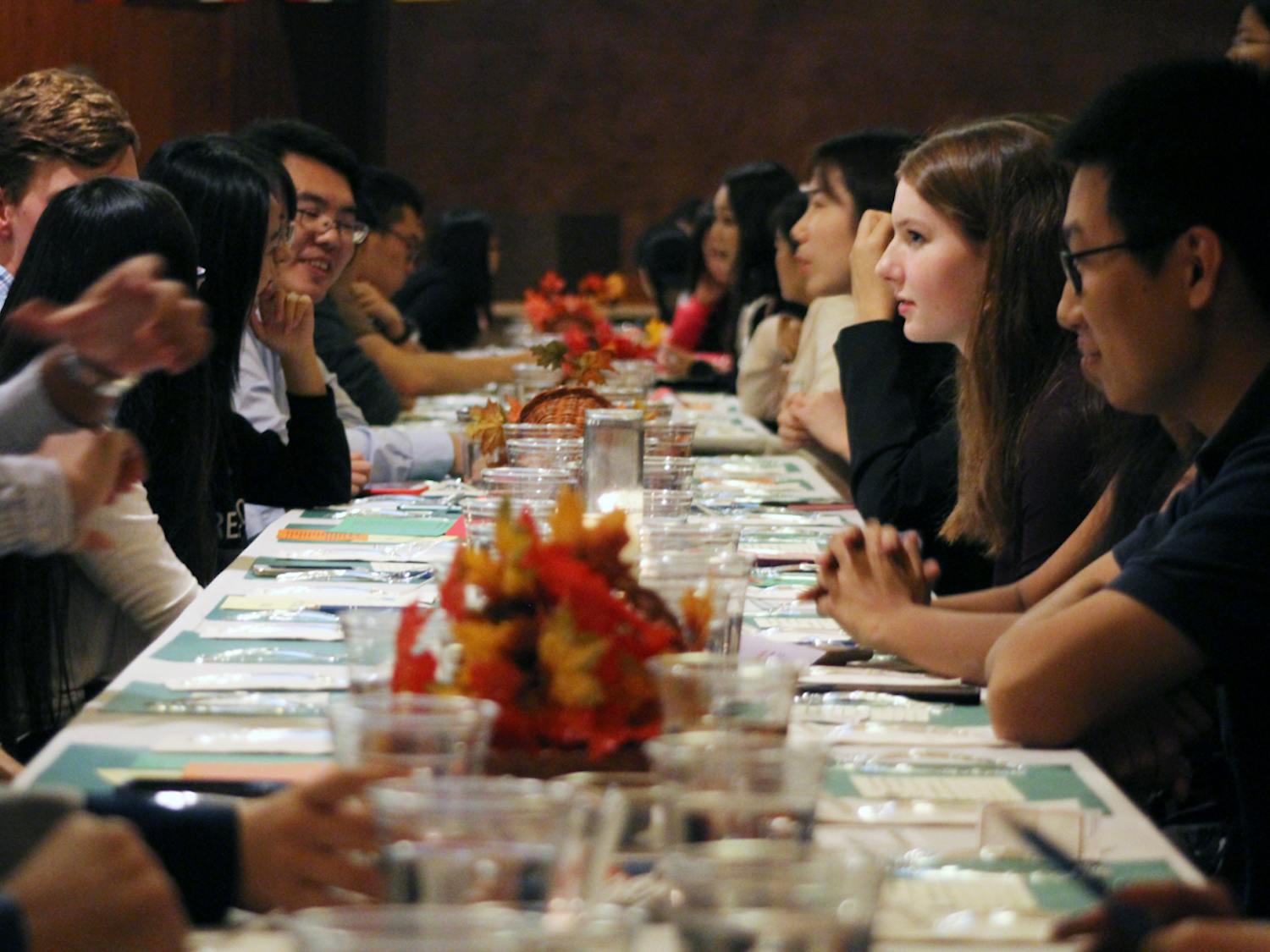 Strangers sit together and wait for their food before the banquet begins. Typically, UF President Kent Fuchs would have attended and spoken but instead had to attend the football game.