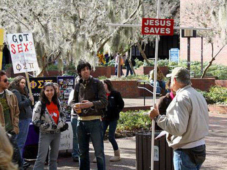 Junior Lofton, a Christian preacher, talks to a group of pro-Israeli protesters and students. Lofton, 73, has been preaching to students for 32 years as of April 2014 and typically visits Turlington Plaza three days a week.
