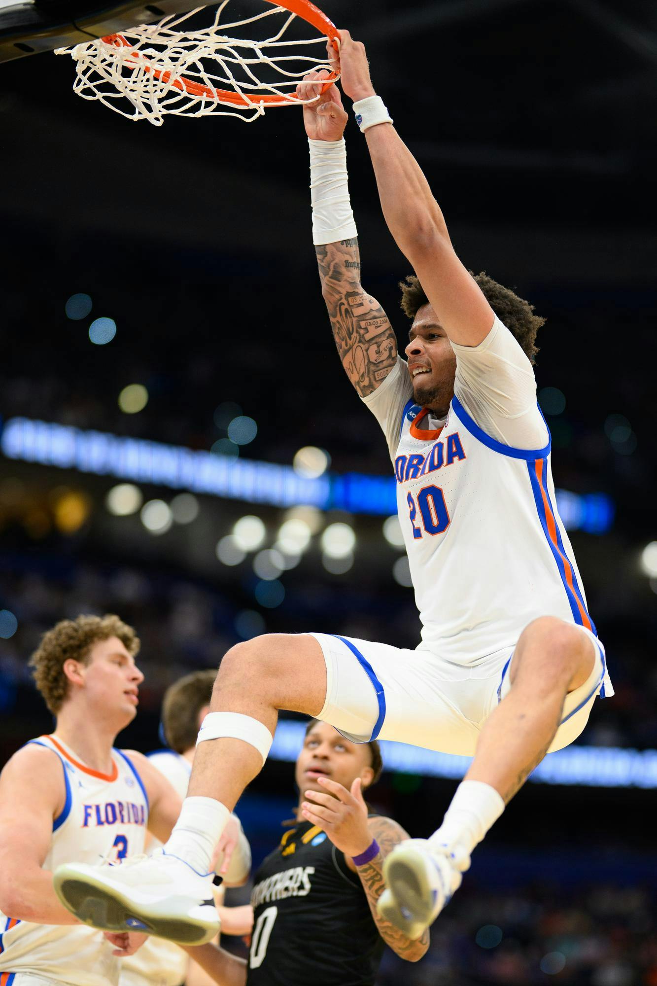 Florida guard Isaiah Brown (20) hangs on the rim after a dunk during the first half of an NCAA Tournament first round game against Prairie View A&M, Friday, March 20, 2026, in Tampa, Fla.