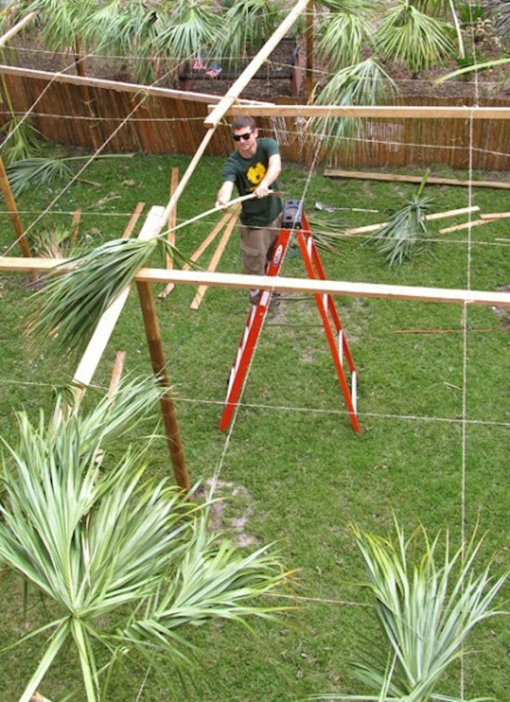 <p>Jeffrey Kaplan, 25, UF Hillel's program director, helps to construct one of Florida's largest sukkahs.</p>