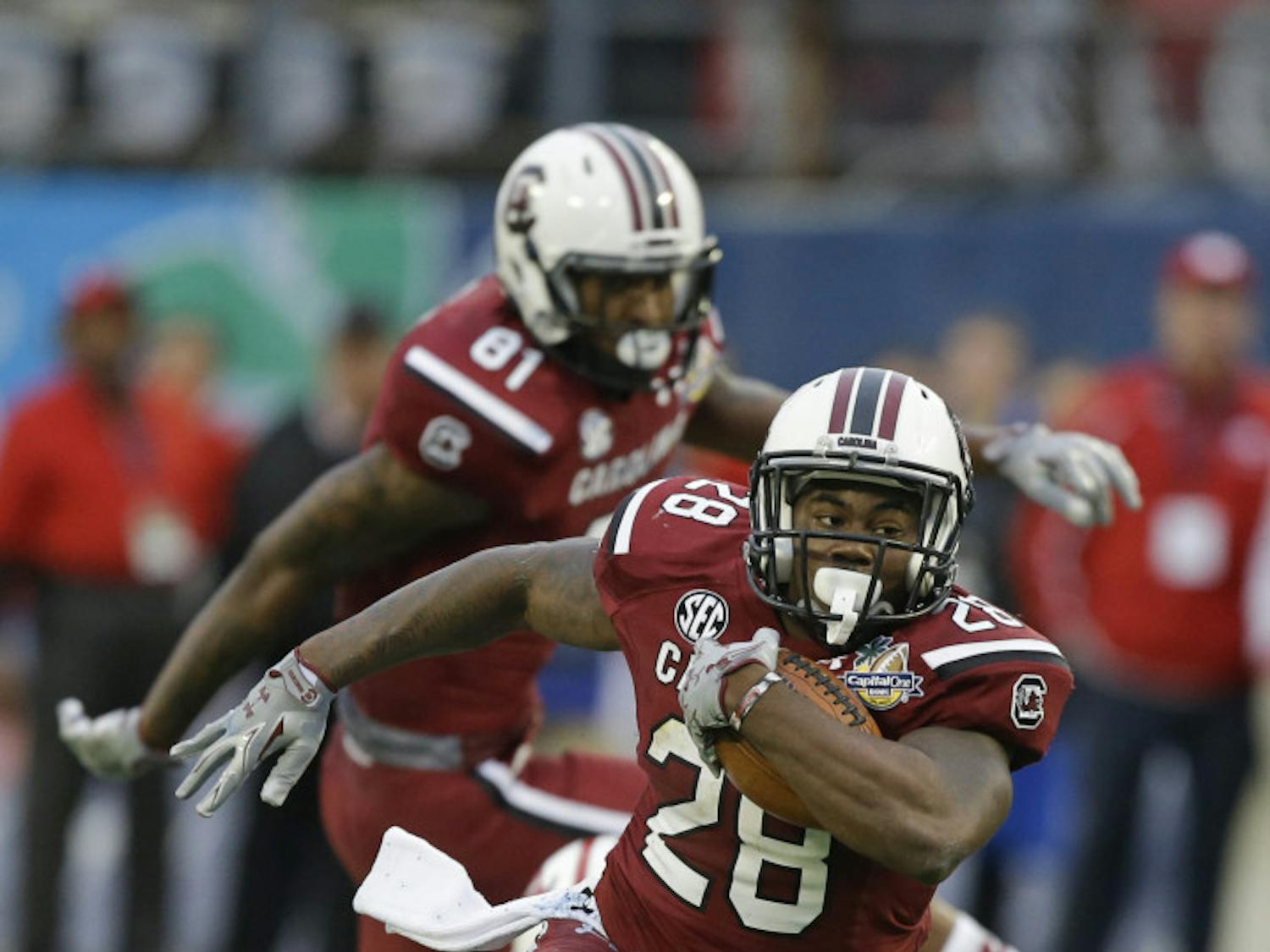 In this Jan. 1, 2014, file photo, South Carolina running back Mike Davis (28) gains yardage against Wisconsin during the second half of the Capital One Bowl NCAA college football game in Orlando, Fla. Steve Spurrier says 1,000-yard rusher Mike Davis hadn't practiced last week and might not be ready when the ninth-ranked Gamecocks open the season against No. 21 Texas A&amp;M tonight.