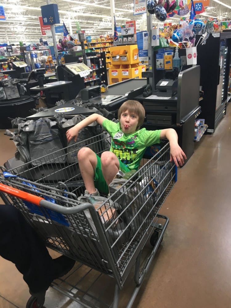 Logan Robbins sitting in his shopping cart of purchased items.
&nbsp;