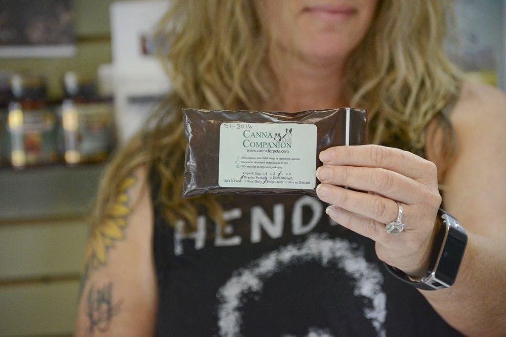 <p>Kat Drawdy, 44, holds up a package of Canna Companion, a hemp-based supplement for pets. Drawdy and her partner, Joy, own the local pet store Earth Pets. The sale of the product touched off a controversy over the legality of hemp in Florida.</p>