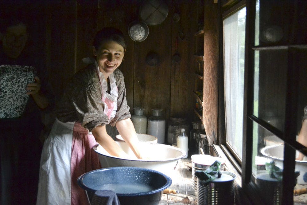 <p>Val Leitner, 36, washes off homemade biscuit batter off her hands in a water bowl during the living history Reconstruction era event at Dudley Farm Historic State Park on Sept. 4, 2015. Leitner was participating as one of the living historians and cooked food for other volunteers on a wood stove.</p>