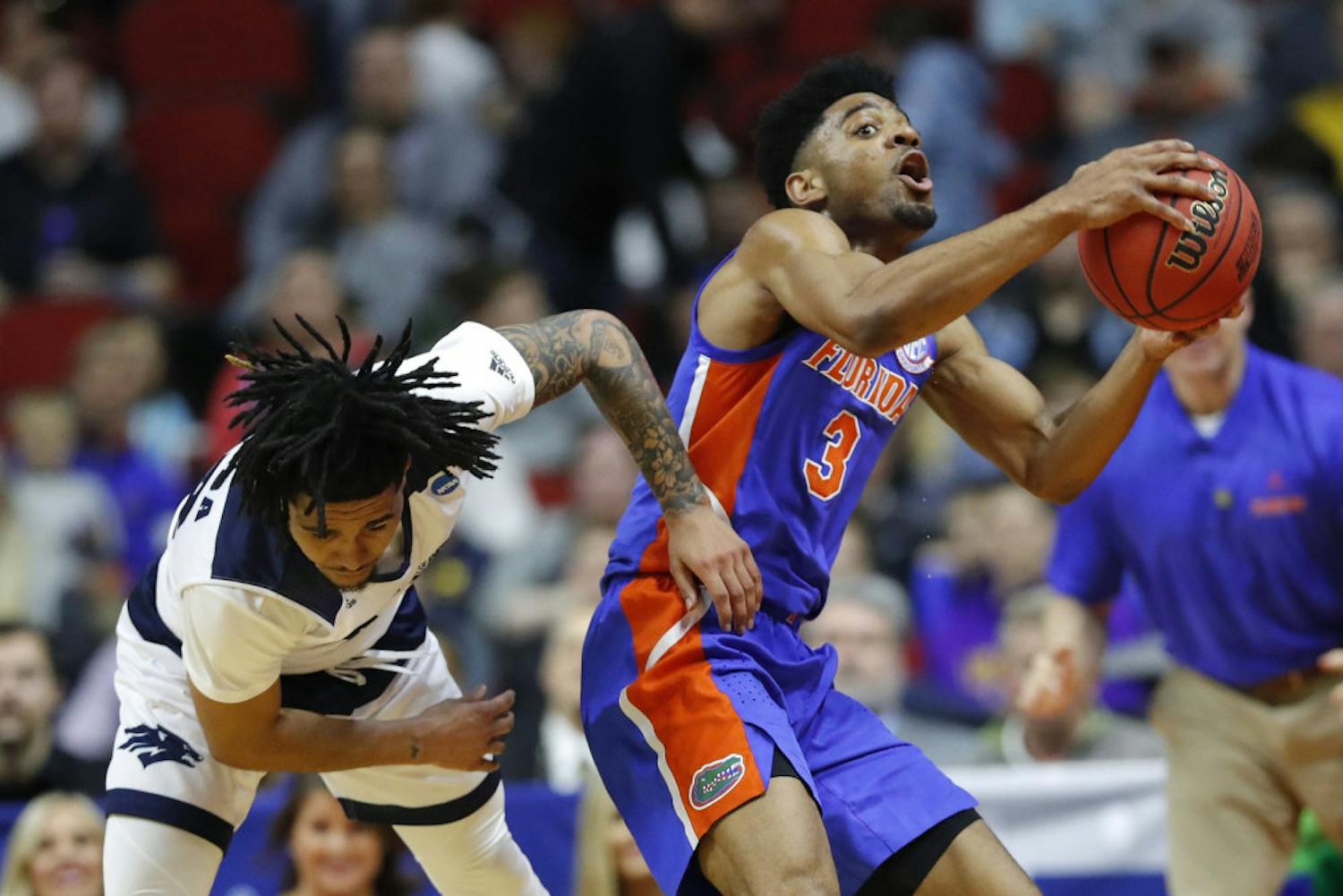 Florida guard Jalen Hudson (right) grabs a loose ball over Nevada guard Jazz Johnson during the Gators’ 70-61 win in the First Round in the NCAA Tournament on Thursday in Des Moines, Iowa. 